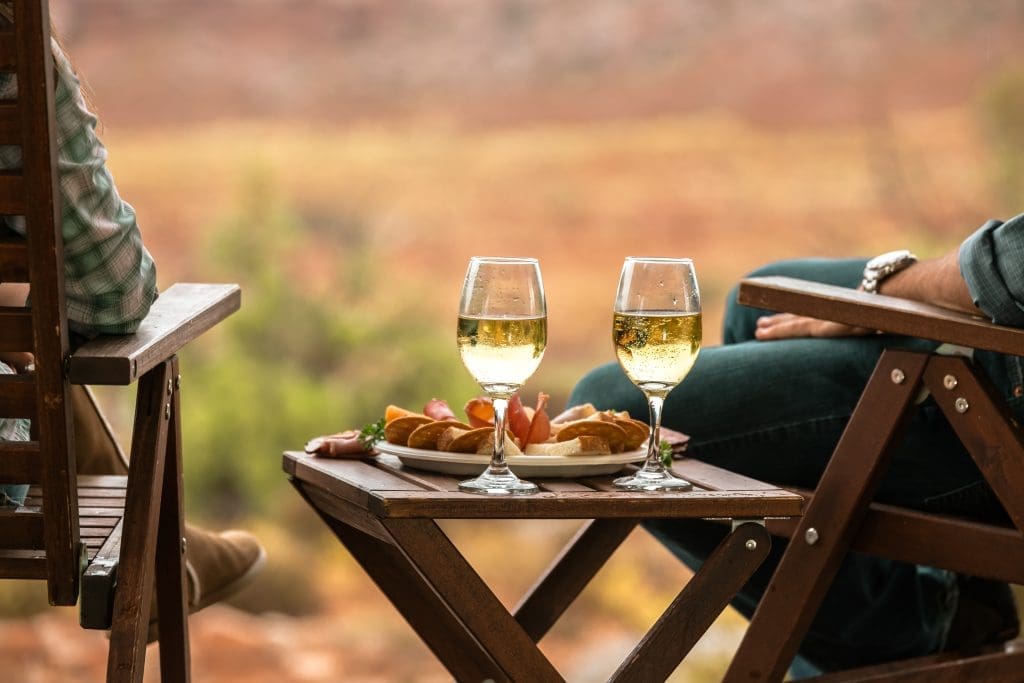 people glamping with wine and a charcuterie board on a table